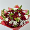 Mixed flower bouquet with burgundy daisies, white chrysanthemums, lime green snapdragons and red roses